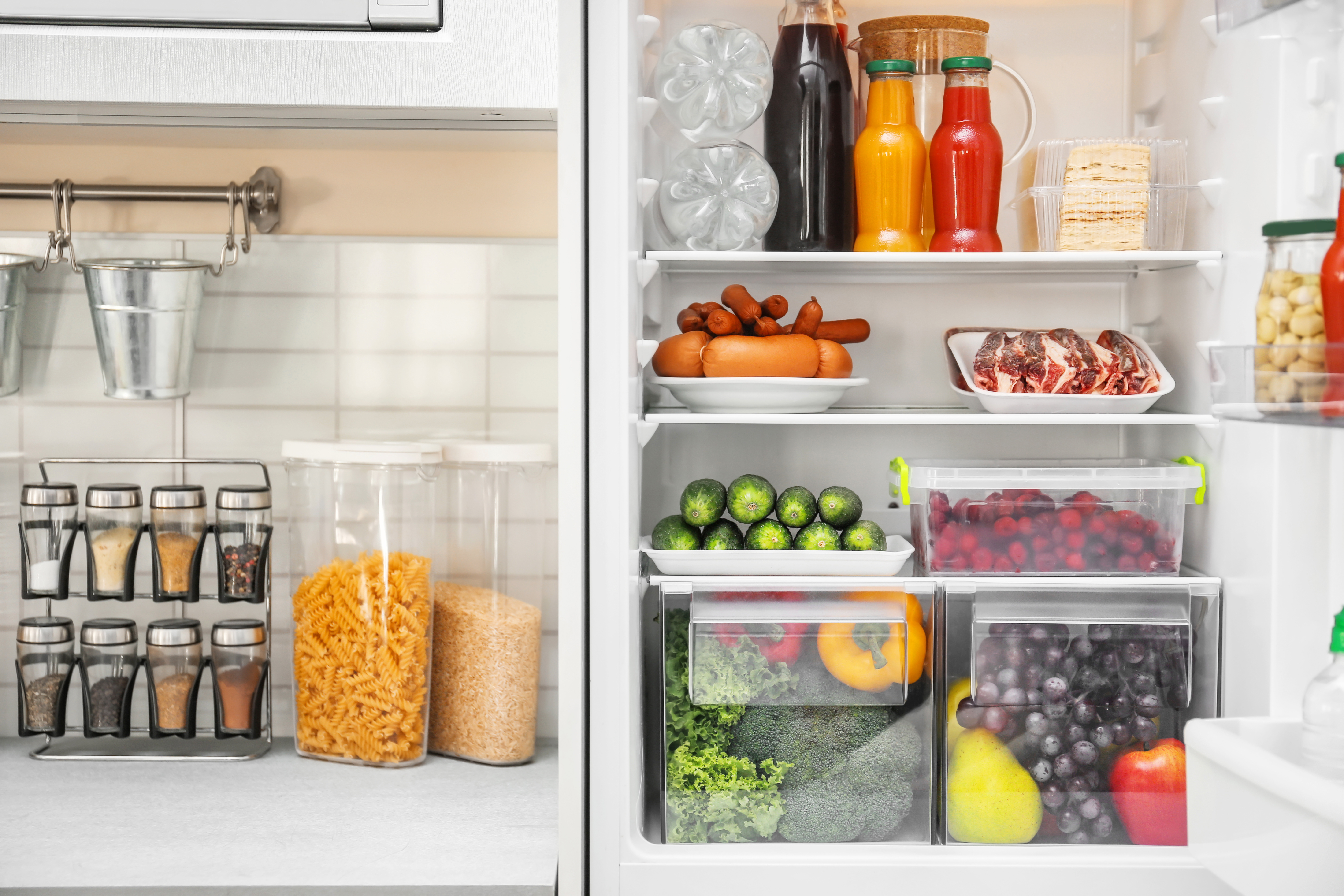 Refrigerator organised into food safety zones with raw meat separated from ready-to-eat foods and vegetables in drawers